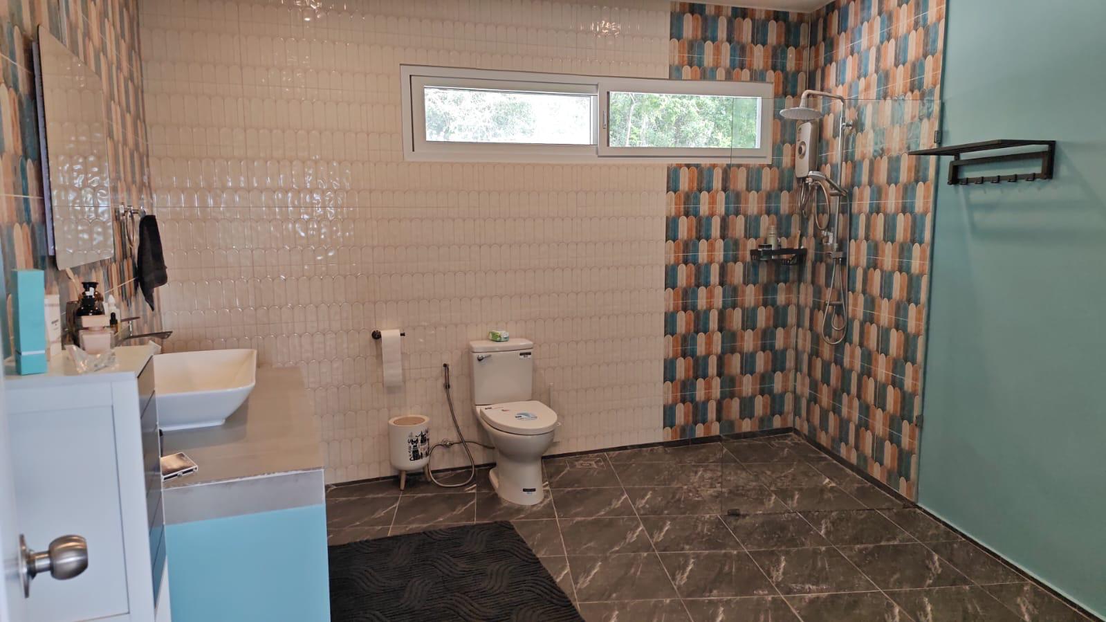 Bathroom with scallop-pattern tile shower and vessel sink