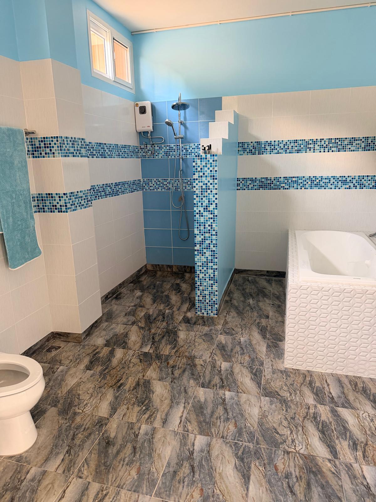 Finished bathroom with bathtub and rain shower