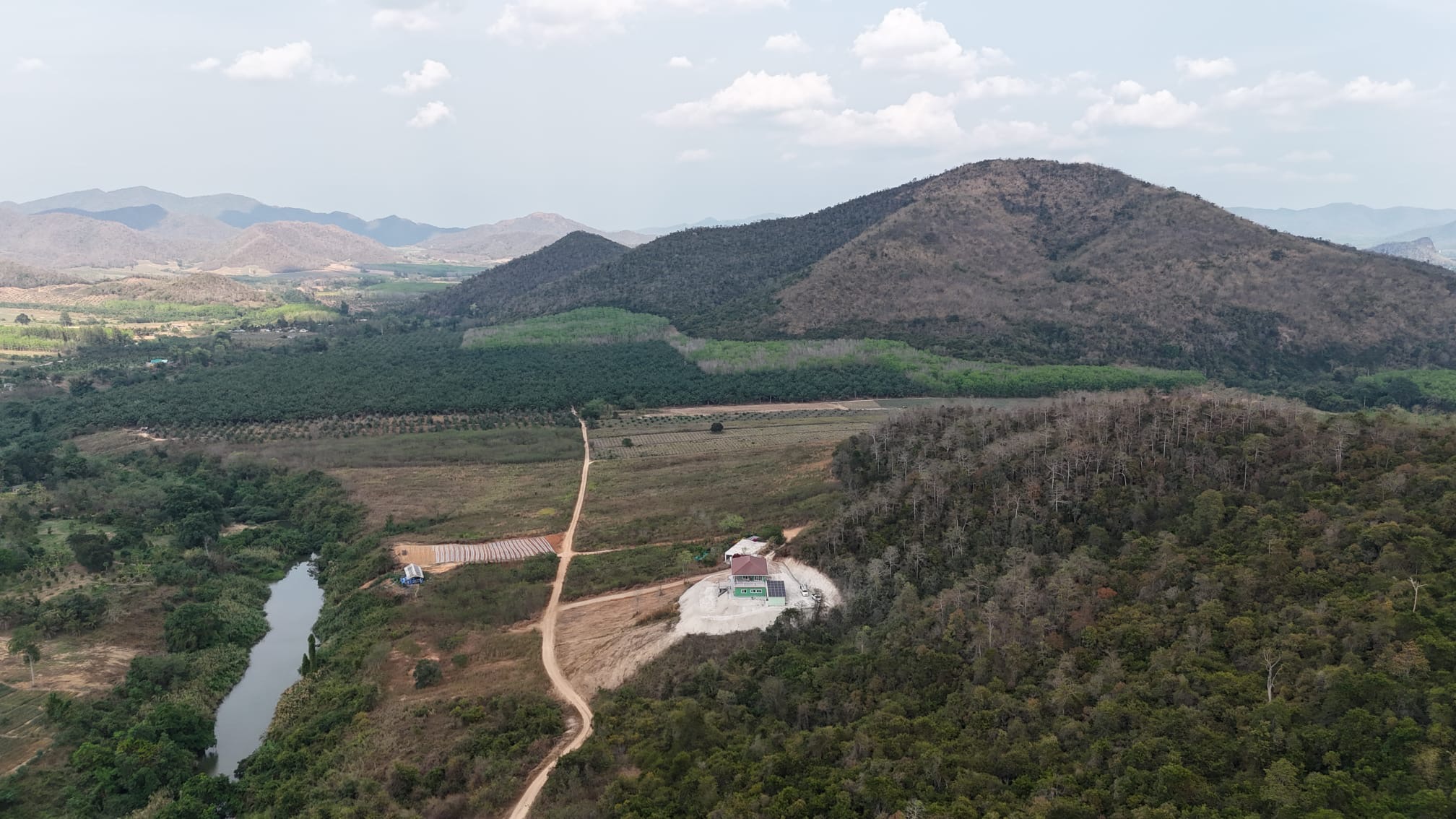 Aerial view of Riverside house beside the river, surrounded by hills and forest in Pran Buri