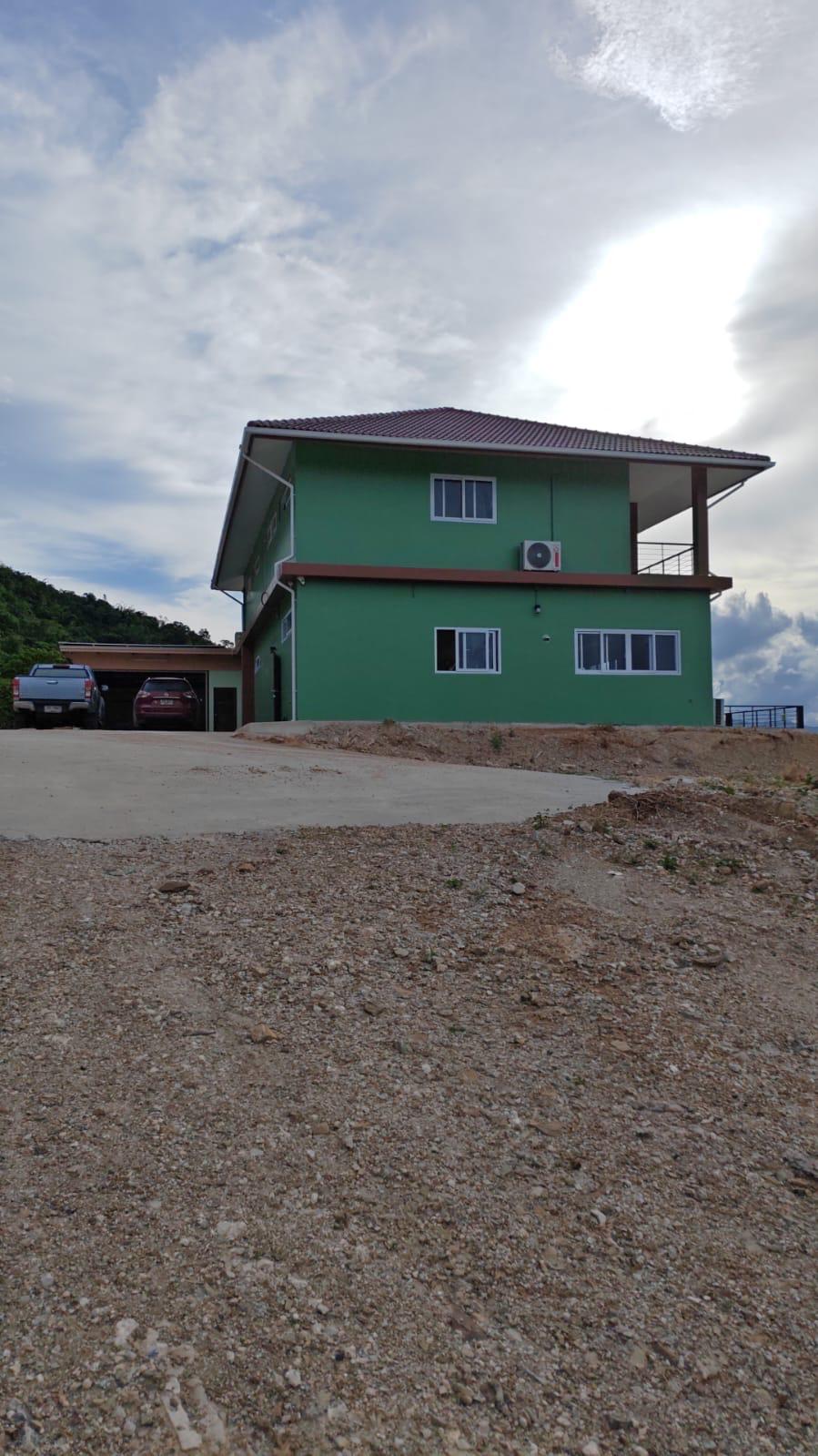 The house seen from a distance on the hillside