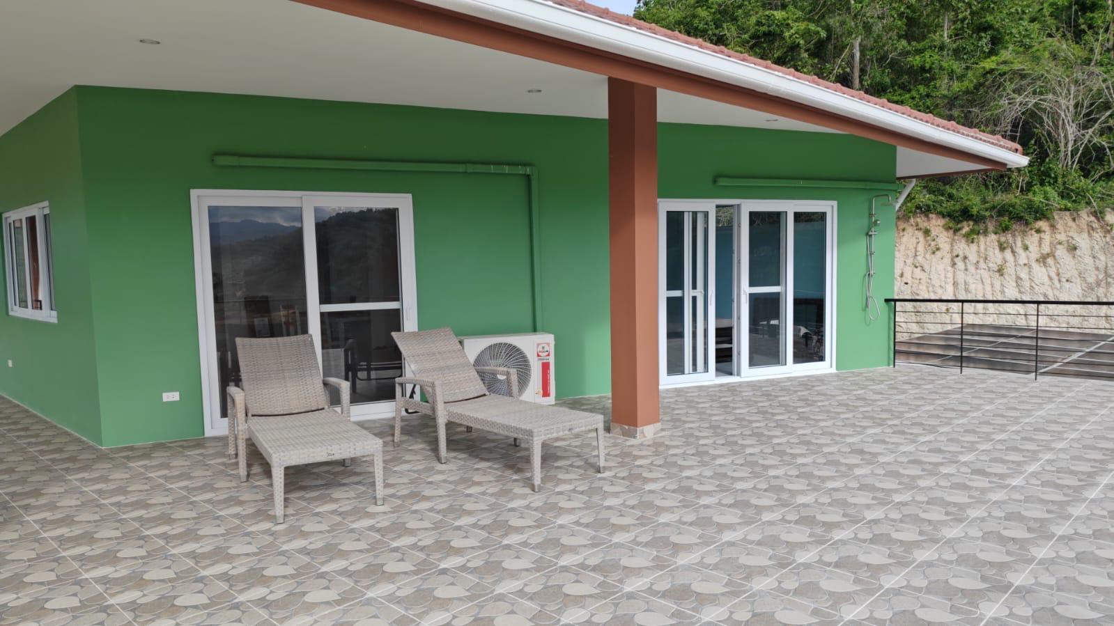 Terrace with lounge chairs, wide view with mountain backdrop