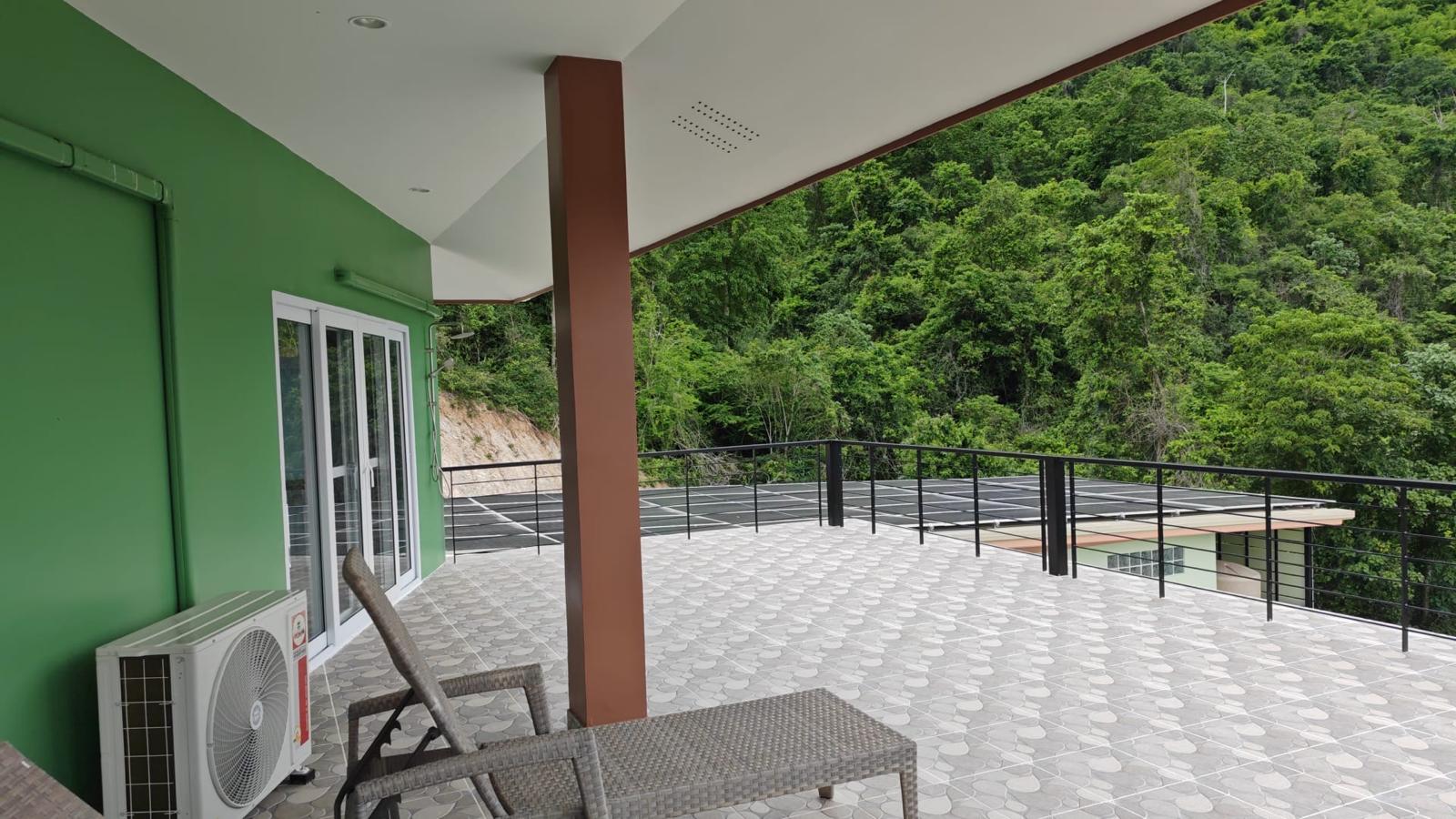 Terrace with view of the rooftop solar panels and forest